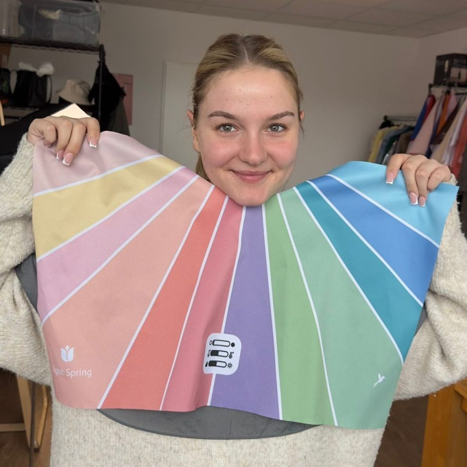 Junge Frau hält eine große Farbpalette mit verschiedenen Farbtönen.